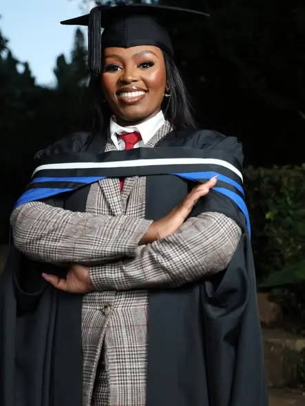 A graduate, arms crossed