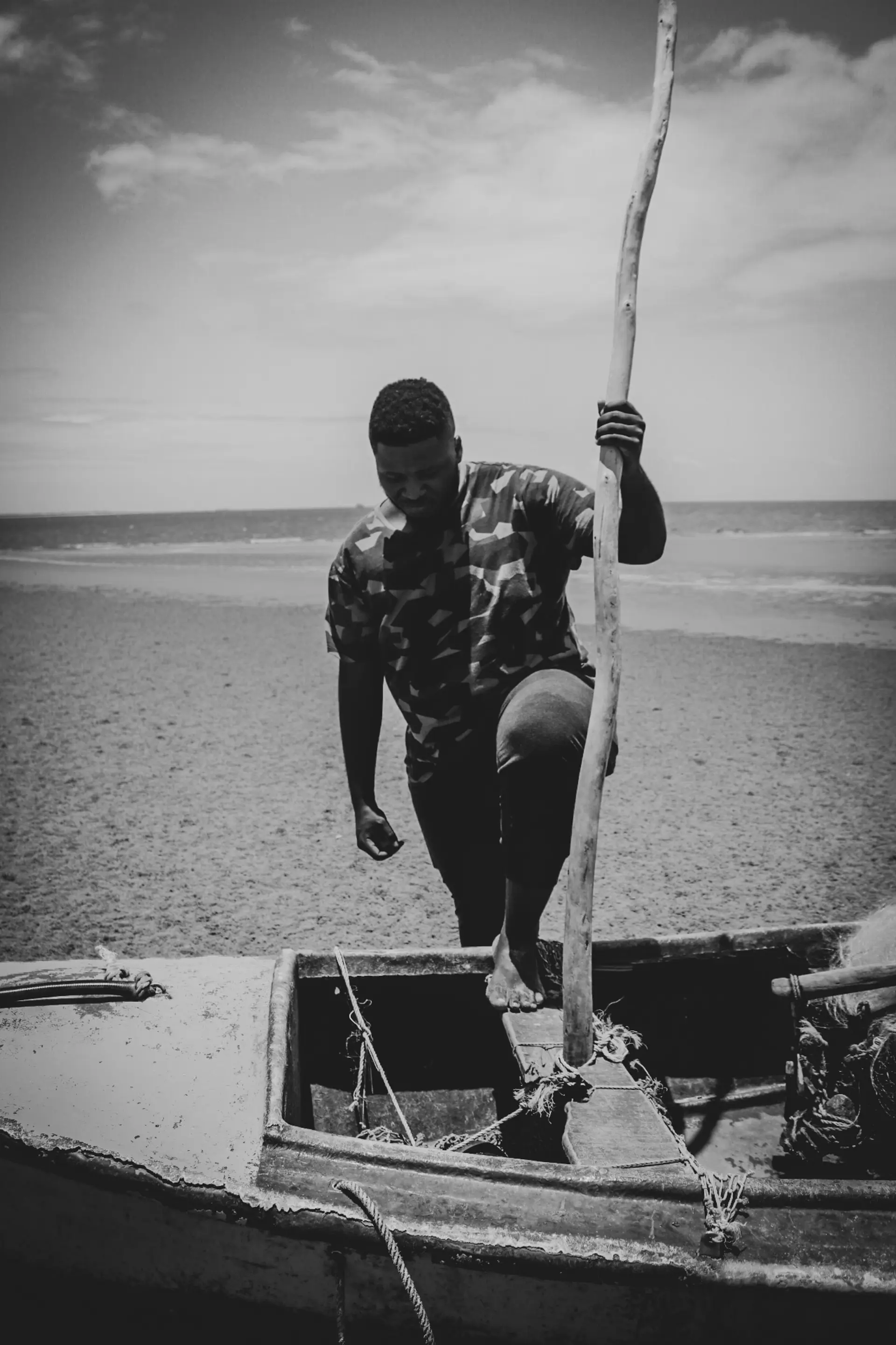 A fisherman on a boat, in black and white