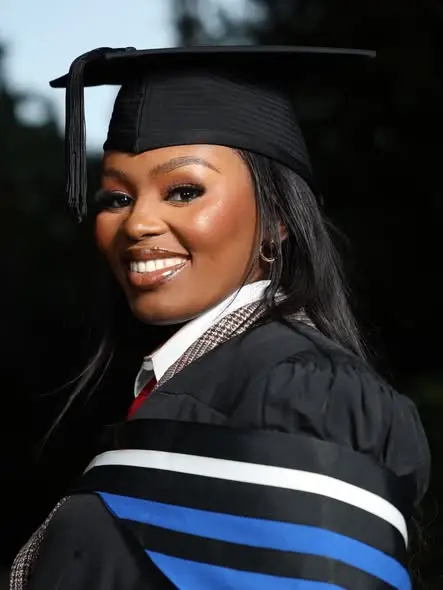 A graduate smiling in her gown