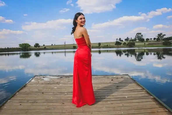 A red dress on a jetty over still water